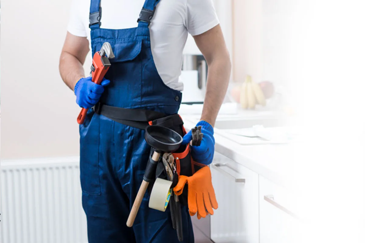 Plombier équipé de sa ceinture d’outils avant une réparation de WC
